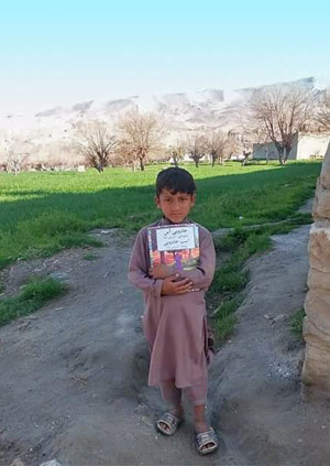 a boy from Laghman province with a Hoopoe book